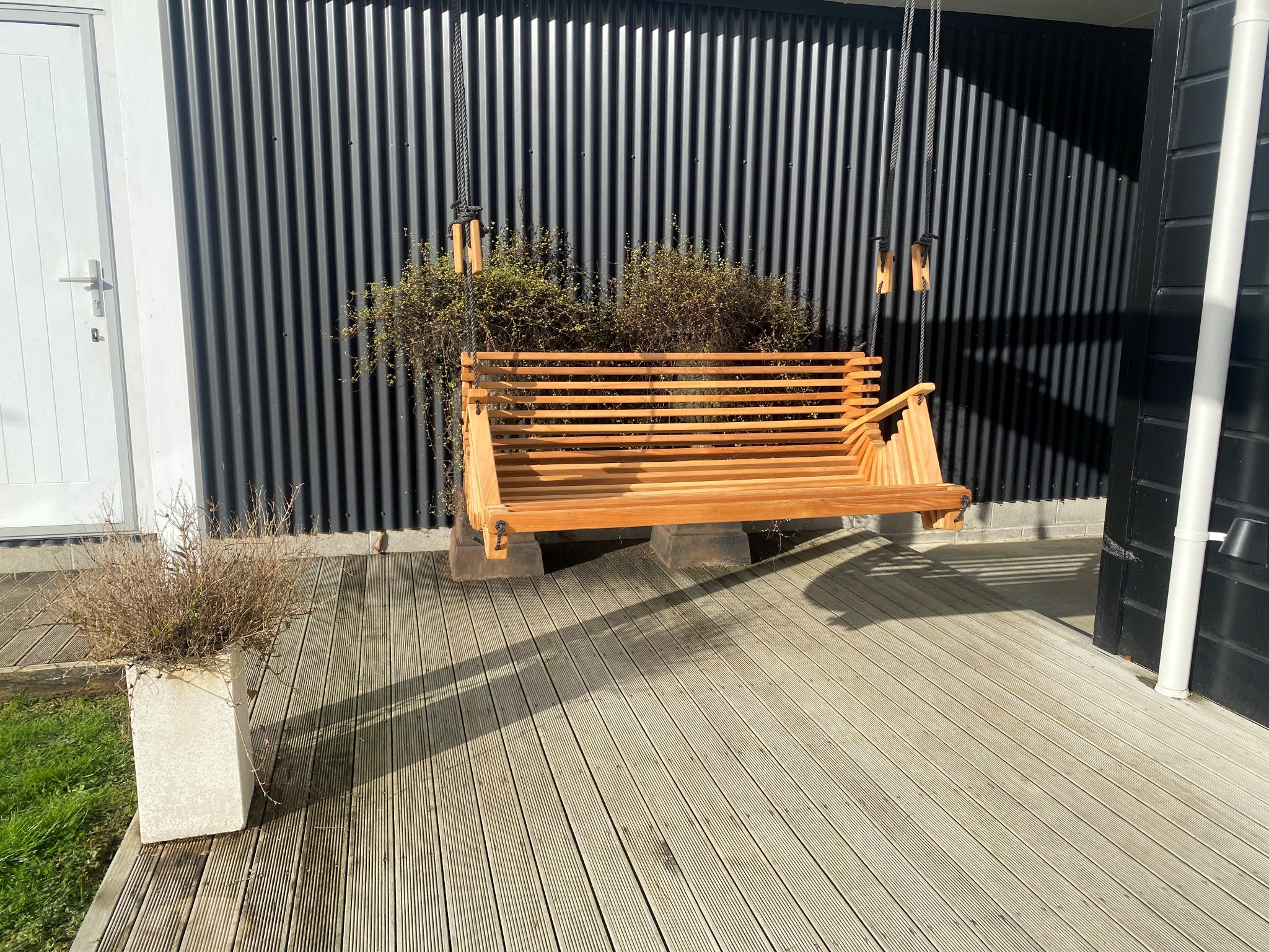 Mo & Co Macrocarpa swing with black rope on a deck